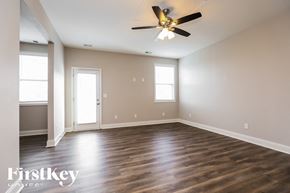 Murfreesboro house for rent - A spacious room with a ceiling fan and hardwood floors.