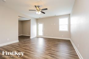 Murfreesboro house for rent - A spacious room with wooden flooring and a ceiling fan.