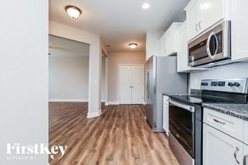 Murfreesboro house for rent - A kitchen with white cabinets and a wooden floor.