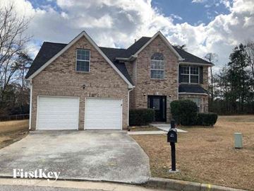 Lithonia house for rent - a brick house with two garage doors and a parking meter
