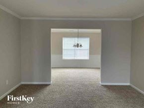 Lithonia house for rent - an empty living room with a window and a chandelier