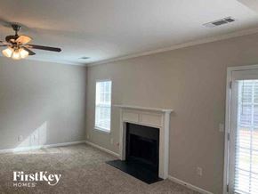 Lithonia house for rent - a living room with a fireplace and a ceiling fan