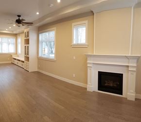 Vancouver apartment for rent - A living room with a fireplace and a ceiling fan.