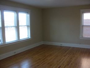 St. Louis apartment for rent - A room with wooden floors and two windows.