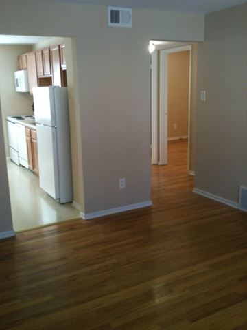 St. Louis apartment for rent - A kitchen with a white refrigerator and wooden floors.