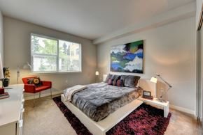 Bellevue apartment for rent - Bedroom with Large Window, Carpet through out but has a burgundy accent rug and abstract painting on wall and Low Elevated Mattress