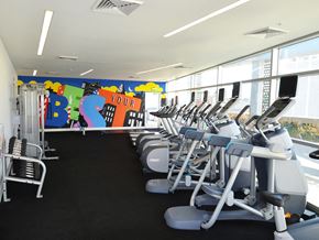 Philadelphia apartment for rent - a row of cardio machines in a gym with a colorful wall
