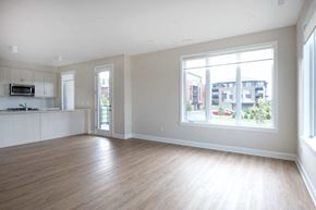 Ottawa apartment for rent - an empty living room with a large window and wood floors