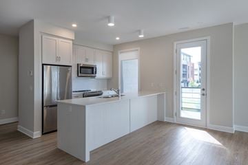 Ottawa apartment for rent - a kitchen with white cabinets and a stainless steel refrigerator