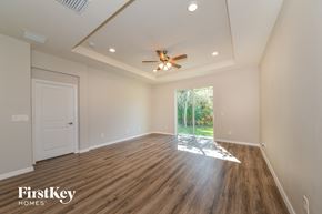 Palmetto house for rent - an empty living room with a ceiling fan and a window