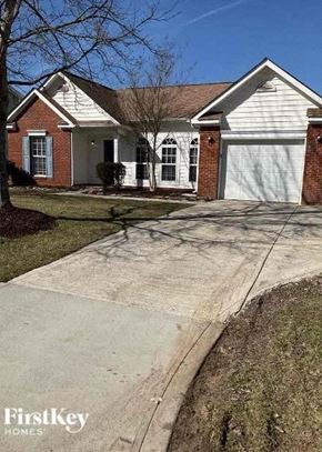 Charlotte house for rent - A brick house with a white garage door and a driveway.