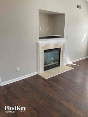 Charlotte house for rent - A fireplace in a room with wooden floors and white walls.