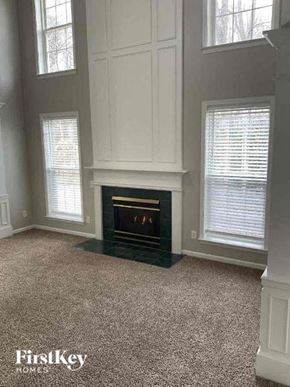 Huntersville house for rent - a living room with a fireplace and three windows