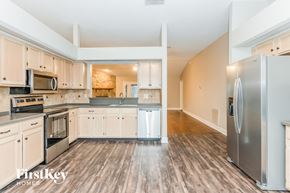 Jacksonville house for rent - a kitchen with white cabinets and stainless steel appliances