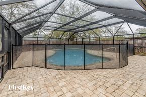 Jacksonville house for rent - a patio with a pool in a screened in pool house