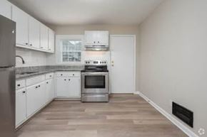 Gainesville apartment for rent - A kitchen with white cabinets and a stainless steel refrigerator.
