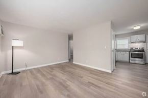 Gainesville apartment for rent - A spacious room with a kitchen area in the background.