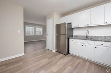 Gainesville apartment for rent - A kitchen with white cabinets and a stainless steel refrigerator.