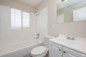 Gainesville apartment for rent - A white toilet sits next to a bathtub in a bathroom.