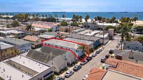 Long Beach apartment for rent - an aerial view of a building with a red roof and the ocean in the background