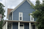 Owosso apartment for rent - a blue house with white trim and a brown roof