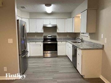 St Augustine house for rent - a kitchen with white cabinets and stainless steel appliances