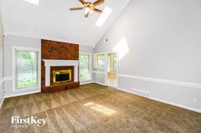 Bartlett house for rent - A room with a fireplace and a ceiling fan.