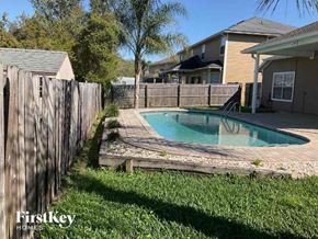 Jacksonville house for rent - A pool surrounded by a wooden fence in a backyard.