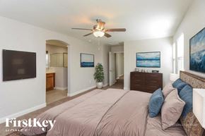 Mesa house for rent - A bedroom with a bed, a ceiling fan, and a painting on the wall.