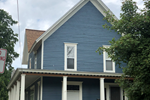 Owosso apartment for rent - a blue house with white trim and a brown roof