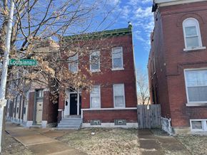 St. Louis apartment for rent - A street view of a row of houses with a sign that says Louisiana.