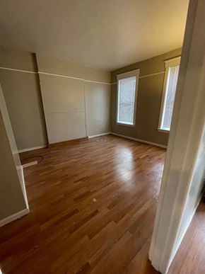 St. Louis apartment for rent - A room with wooden flooring and a window with blinds.