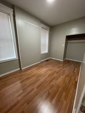 St. Louis apartment for rent - A room with wooden flooring and white walls.