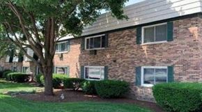 Lisle apartment for rent - A brick building with a signboard in front.
