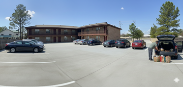 Tulsa apartment for rent - A man unloads luggage from a car in a parking lot.