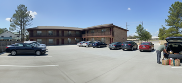 Tulsa apartment for rent - A man is loading bags into the trunk of a car in a parking lot.