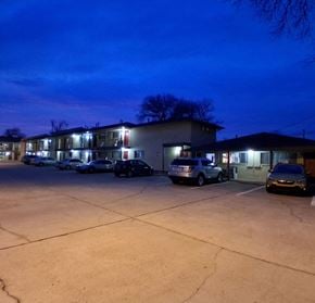 Tulsa apartment for rent - A parking lot with several cars and a building in the background.