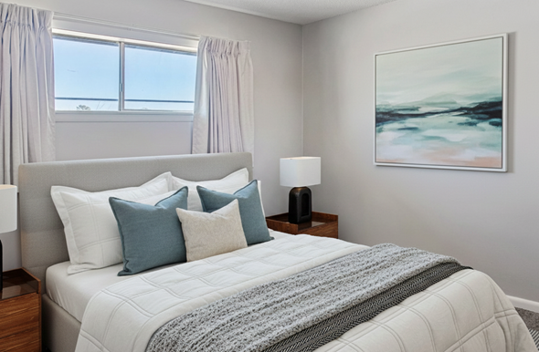 Tulsa apartment for rent - A bedroom with a large bed and a painting on the wall.