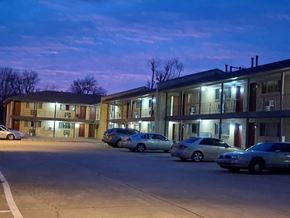 Tulsa apartment for rent - A parking lot with cars and a building in the background.
