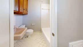 Tulsa apartment for rent - A white bathroom with a toilet, sink, and bathtub.