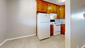 Tulsa apartment for rent - A kitchen with wooden cabinets and white appliances.