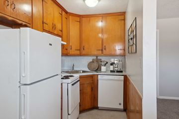 Tulsa apartment for rent - A kitchen with wooden cabinets and white appliances.