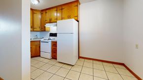 Tulsa apartment for rent - A kitchen with wooden cabinets and white appliances.
