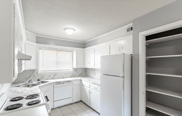Tulsa apartment for rent - A white kitchen with a refrigerator and a stove.