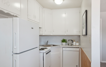 Tulsa apartment for rent - A white fridge in a kitchen with a stove and dishwasher.