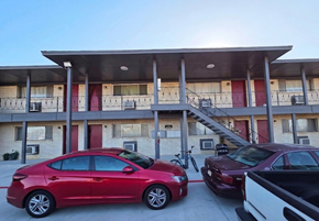 Tulsa apartment for rent - A red car is parked in front of a building with a red door.