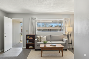 Tulsa apartment for rent - A living room with a grey couch, a wooden coffee table, and a lamp.