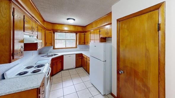 Tulsa apartment for rent - A kitchen with a white refrigerator and a white stove top oven.