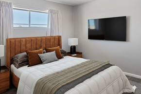 Tulsa apartment for rent - A bedroom with a large bed and a flat screen TV mounted on the wall.
