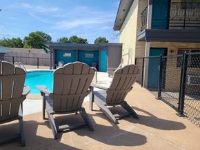 Tulsa apartment for rent - A poolside scene with chairs and a pool.